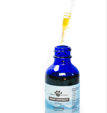 Blue bottle of Earth Buddy cbd oil for dogs with dropper showing cbd oil.