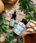 Two bottles of a product with dropper on a wooden surface with leaves and mushrooms