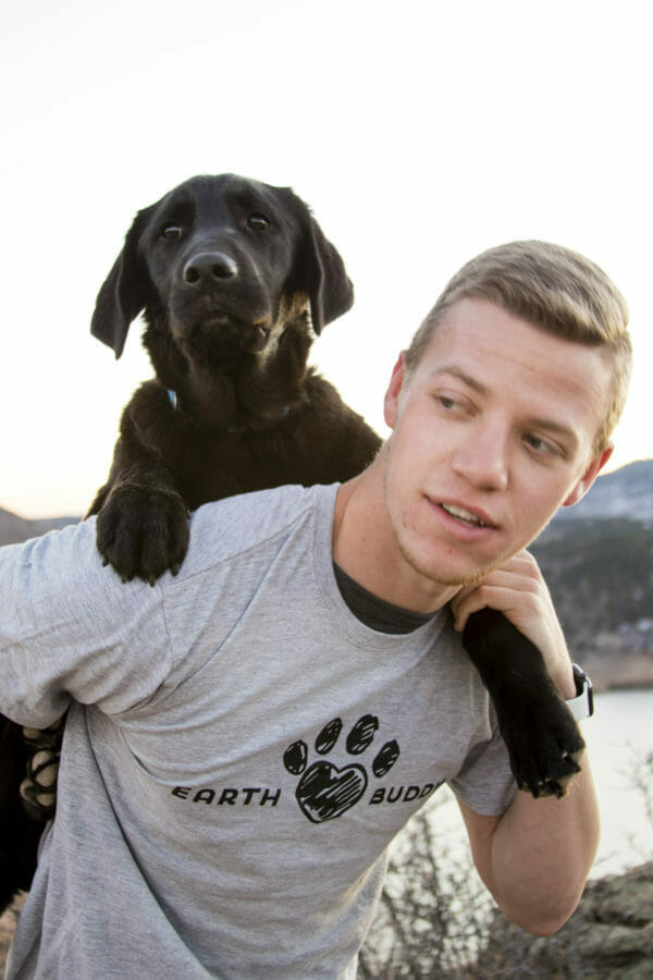 A puppy and an owner wearing Earth Buddy Apparel. Earth Buddy makes pet CBD products and supplements